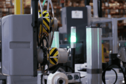 A machine wearing a yellow helmet, indicating safety precautions in a construction or industrial setting.