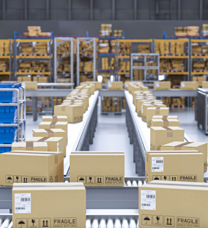 Cardboard boxes stamped "FRAGILE" travel along a warehouse conveyor belt past tall storage racks.